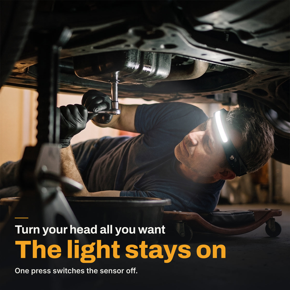 Mechanic lying under a car with the HaloBeam headlamp switched on